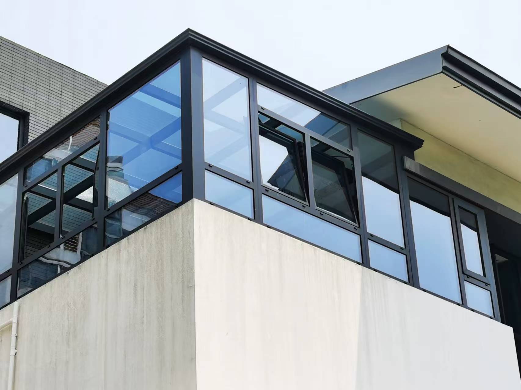 Supplier project photograph of a glazed upper-floor enclosure with dark frames and open awning windows