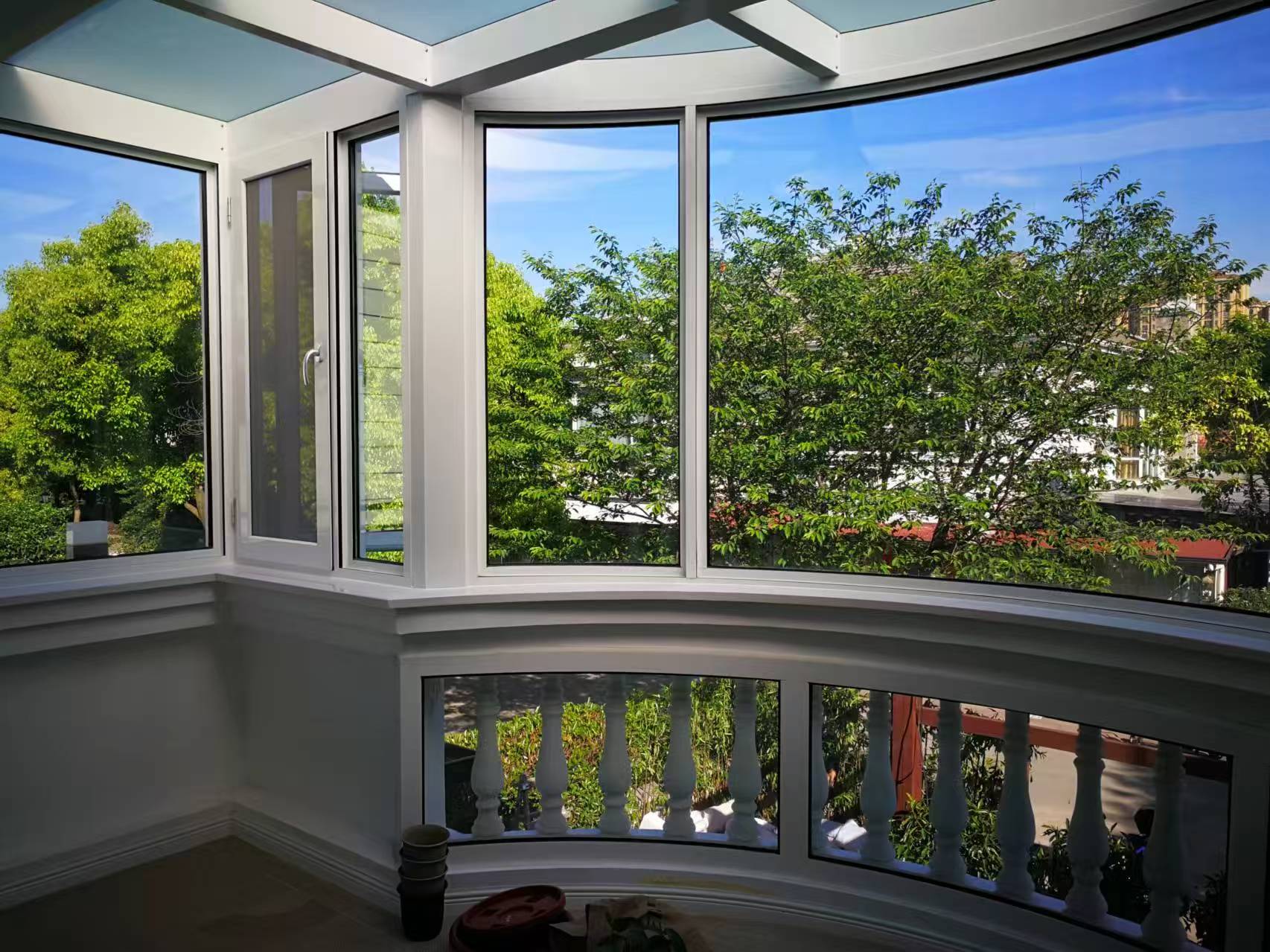 Supplier project photograph of white-framed residential windows arranged around a curved bay